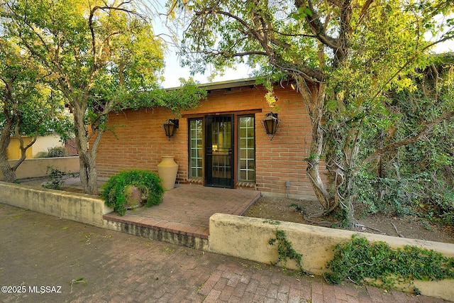 view of exterior entry with a patio