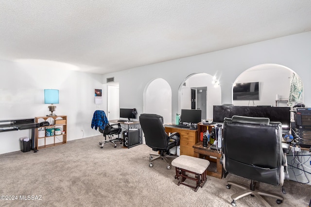 carpeted office featuring a textured ceiling