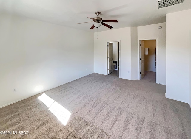 carpeted spare room featuring ceiling fan