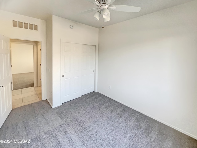 unfurnished bedroom featuring a closet, carpet floors, and ceiling fan