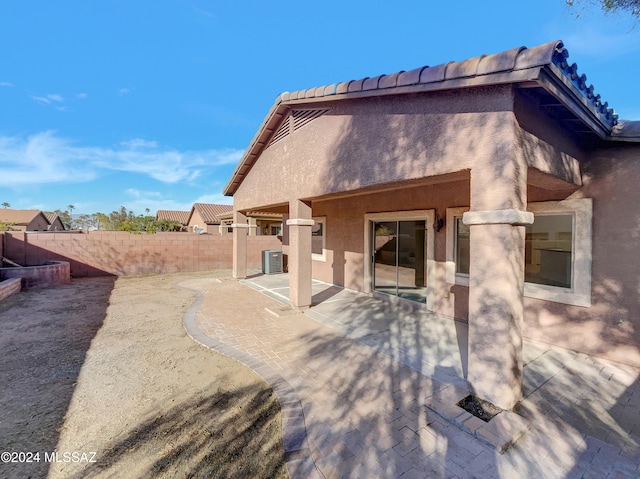 rear view of house featuring cooling unit and a patio