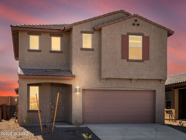 view of front of property with a garage, driveway, and stucco siding