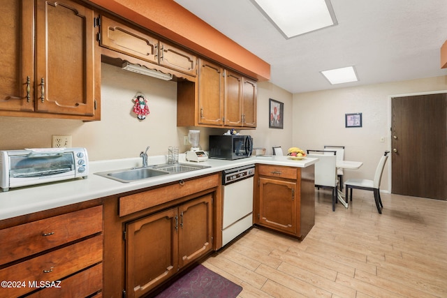 kitchen featuring sink, light hardwood / wood-style flooring, kitchen peninsula, and dishwasher