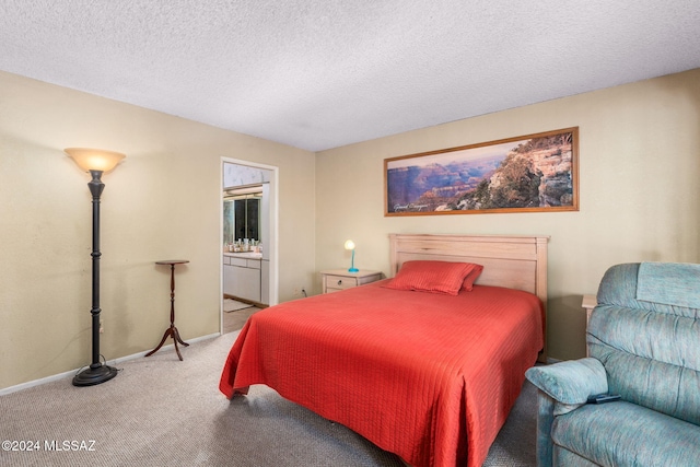 carpeted bedroom featuring a textured ceiling and ensuite bathroom