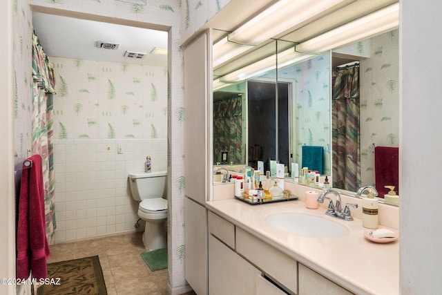 bathroom featuring tile walls, vanity, toilet, and tile patterned flooring