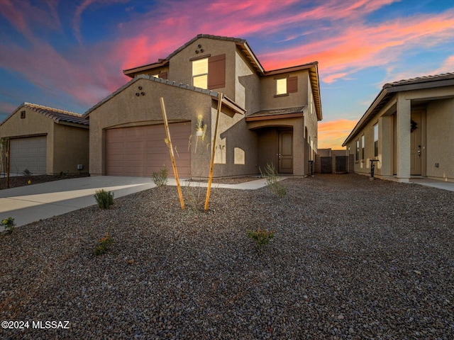 view of front of home featuring a garage, concrete driveway, a tile roof, and stucco siding