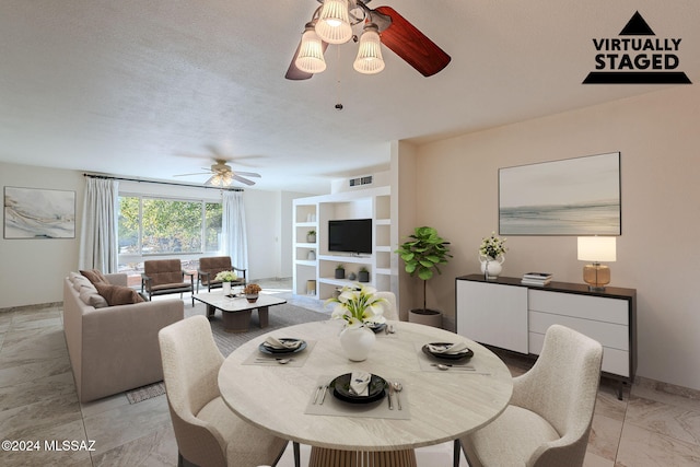 dining room featuring ceiling fan and a textured ceiling