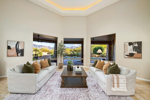 living room with a towering ceiling, a wealth of natural light, and ceiling fan