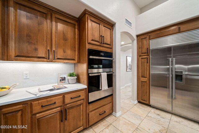 kitchen featuring stainless steel appliances and light tile patterned flooring