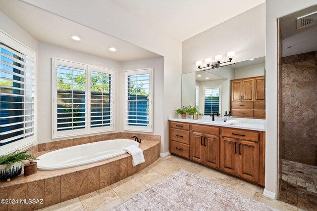 bathroom with vanity, plus walk in shower, and a wealth of natural light