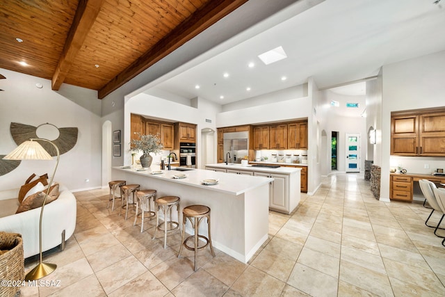 kitchen featuring kitchen peninsula, a breakfast bar, high vaulted ceiling, and wood ceiling