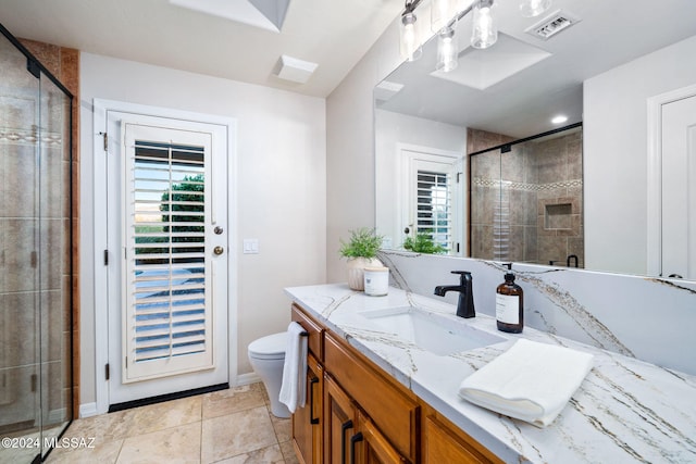 bathroom featuring tile patterned floors, vanity, toilet, and a shower with shower door