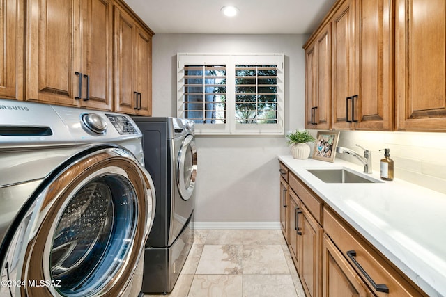 laundry room with washer and dryer, cabinets, and sink