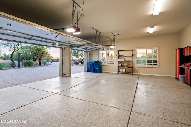 garage at dusk featuring a garage door opener