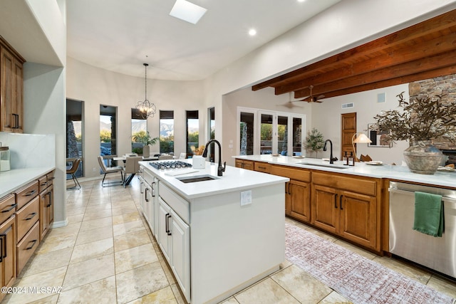 kitchen with sink, hanging light fixtures, beamed ceiling, white cabinetry, and stainless steel appliances