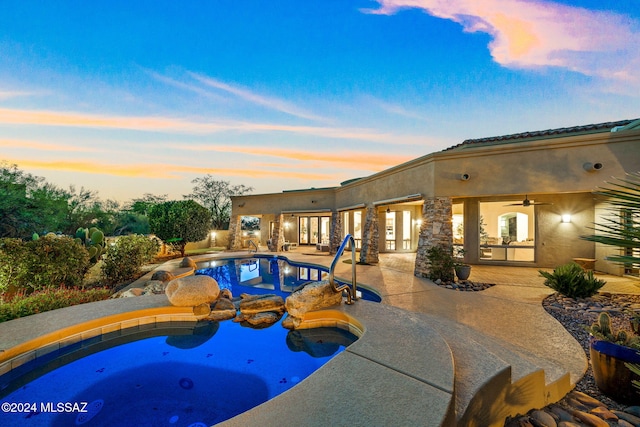 pool at dusk with a patio area, a jacuzzi, and ceiling fan