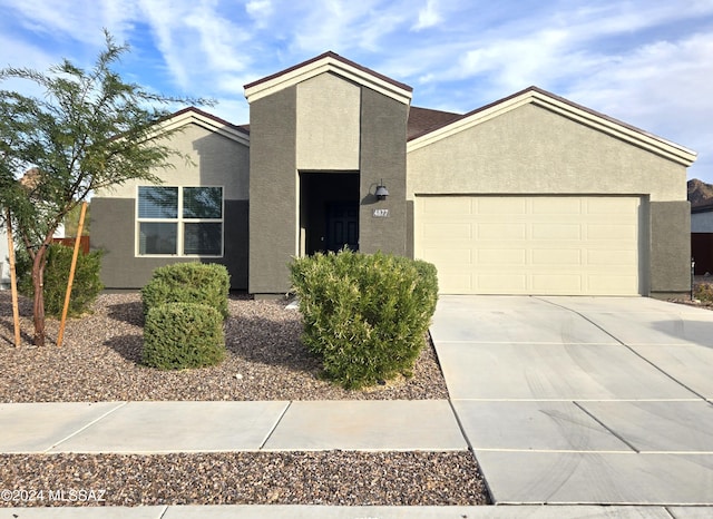 view of front of property featuring stucco siding, driveway, and an attached garage