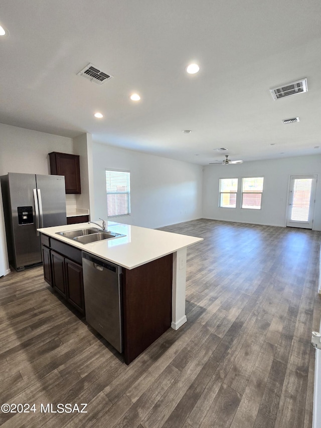 kitchen featuring a sink, visible vents, stainless steel appliances, dark brown cabinets, and dark wood-type flooring