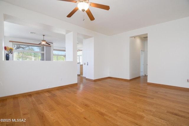 spare room with a ceiling fan, baseboards, visible vents, and light wood-style floors