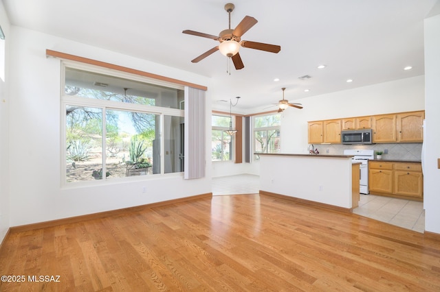 unfurnished living room featuring recessed lighting, baseboards, a ceiling fan, and light wood-type flooring