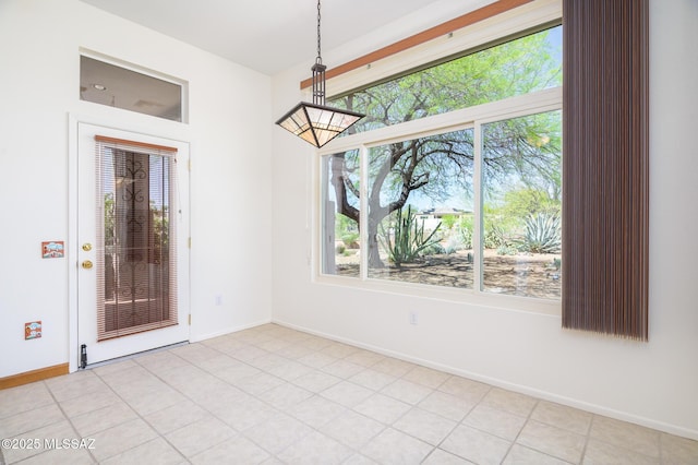 unfurnished dining area with baseboards and a healthy amount of sunlight