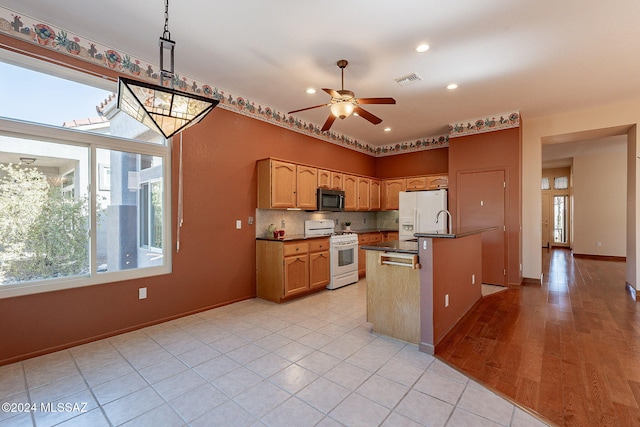 kitchen featuring backsplash, ceiling fan, light wood-type flooring, decorative light fixtures, and white appliances