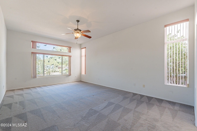 unfurnished room featuring a healthy amount of sunlight, carpet, and a ceiling fan