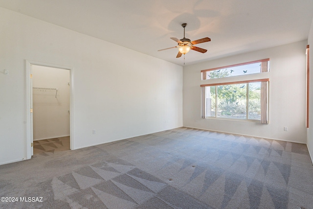 carpeted empty room with a ceiling fan