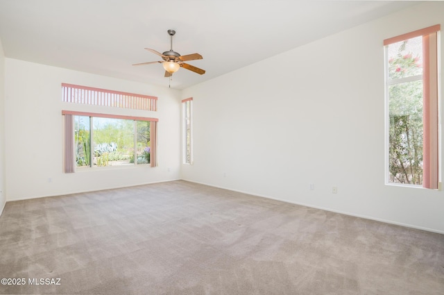 spare room featuring plenty of natural light, carpet, and ceiling fan