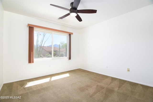 carpeted empty room featuring baseboards, a ceiling fan, and visible vents