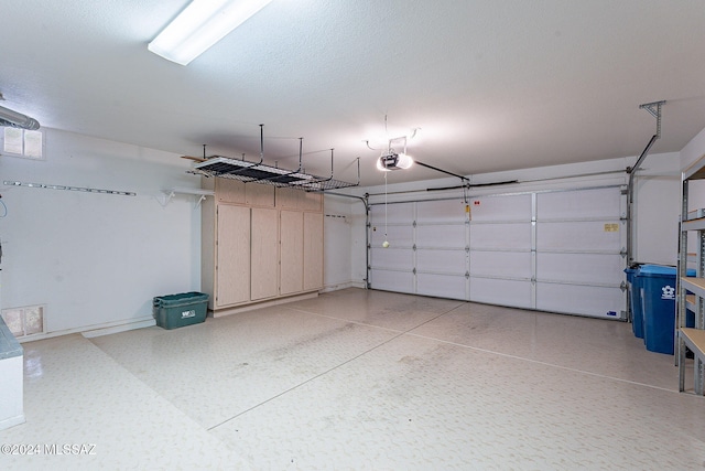 garage with baseboards, visible vents, and a garage door opener