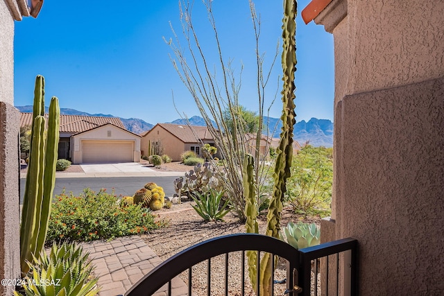 view of yard featuring a garage, a mountain view, and driveway