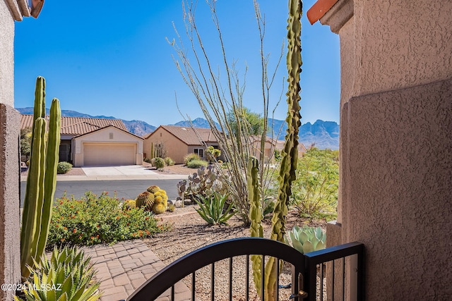 view of yard featuring driveway, an attached garage, and a mountain view