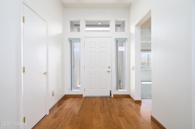 foyer entrance featuring light wood-style floors and baseboards