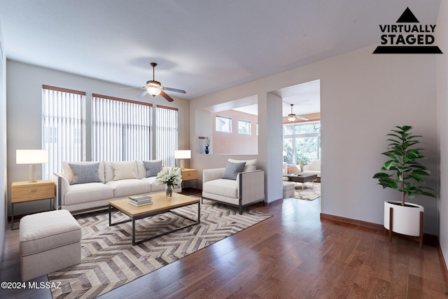 living room featuring a ceiling fan, baseboards, and wood finished floors