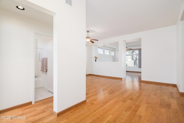 unfurnished room with ceiling fan, visible vents, baseboards, and light wood finished floors