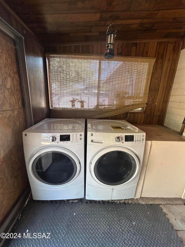 laundry area with washer and clothes dryer, wooden walls, and wood ceiling