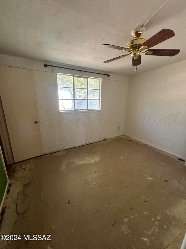 spare room featuring ceiling fan and concrete floors