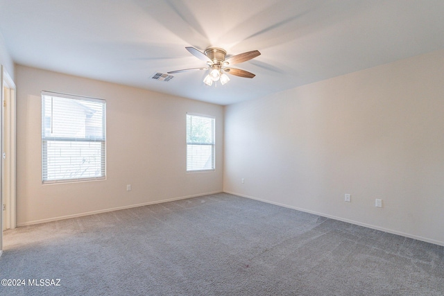 carpeted spare room with ceiling fan