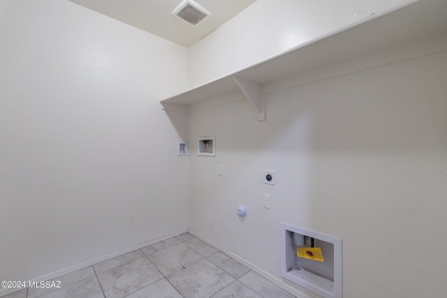 washroom with hookup for an electric dryer, washer hookup, and light tile patterned floors