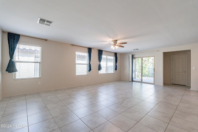 spare room with ceiling fan and light tile patterned floors