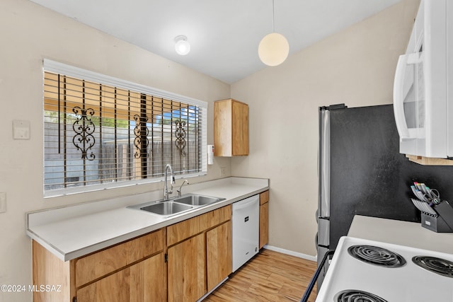 kitchen with white appliances, decorative light fixtures, light wood-type flooring, and sink