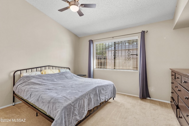 bedroom featuring light carpet, a textured ceiling, and ceiling fan