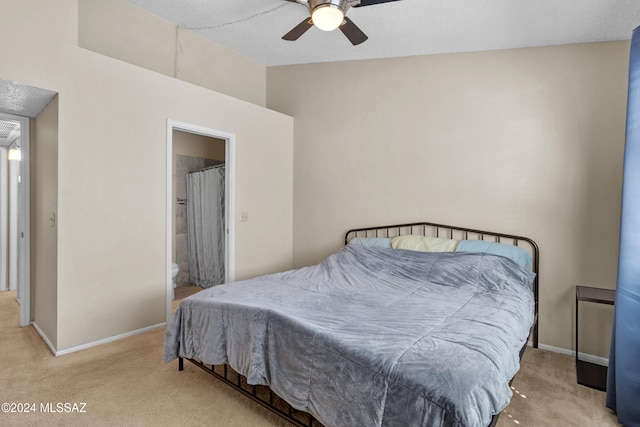 bedroom featuring ceiling fan, light carpet, a textured ceiling, and ensuite bathroom