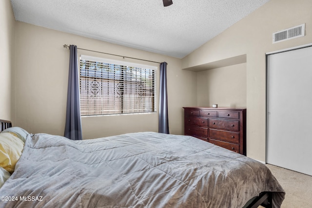 bedroom with ceiling fan, a textured ceiling, carpet, and vaulted ceiling