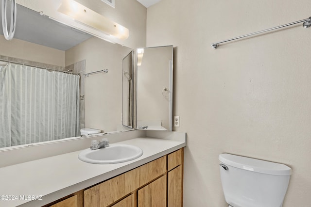 bathroom with vanity, curtained shower, and toilet