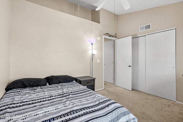 carpeted bedroom with a closet, a textured ceiling, high vaulted ceiling, and ceiling fan