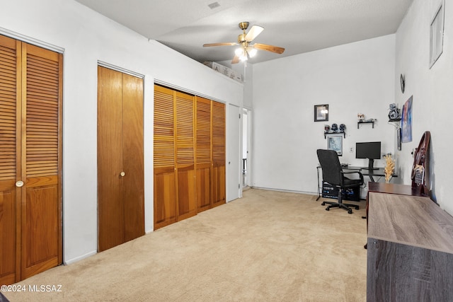 office space with light colored carpet and ceiling fan