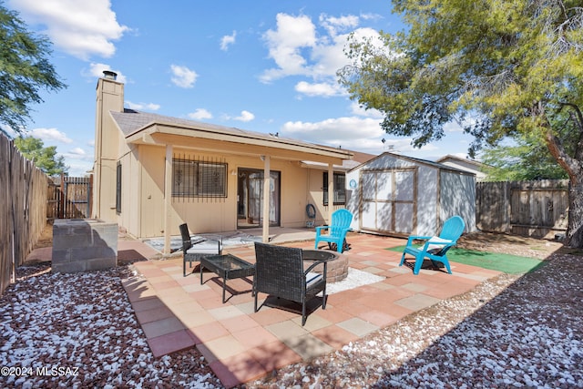 rear view of house with a patio and a shed