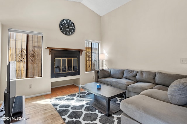 living room with light hardwood / wood-style flooring, vaulted ceiling, and a wealth of natural light